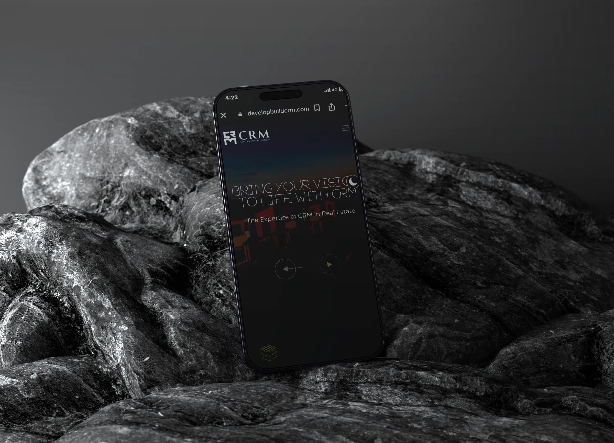CRM Construction and Development mobile site on a phone resting on dark rock